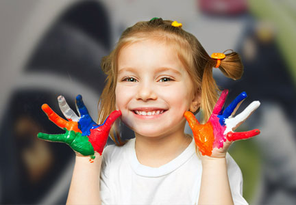 Petite fille avec les mains pleinent de peinture